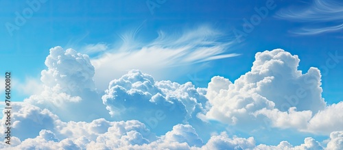 A large cloud is situated in the sky against a backdrop of clear blue sky photo
