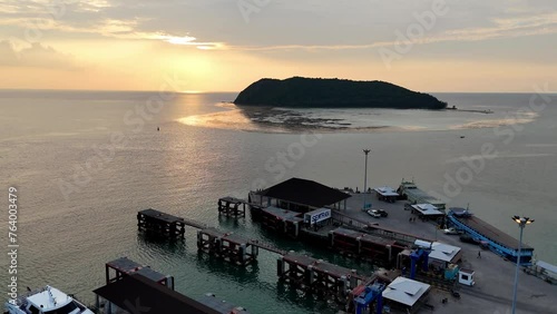 Aerial view of Thongsala Pier (Raja, Lomprayah, Seatran, Night Boat), Koh Phangan, Thailand. Forward drone shot towards beautiful sunset.  photo