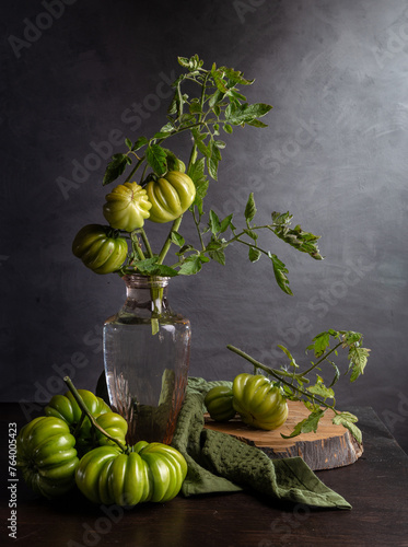 Modern still life with a bouquet of green tomatoes on a dark background