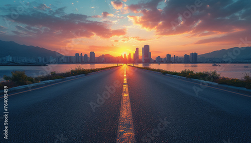 The perspective of the road against the background of sunset and the cityscape