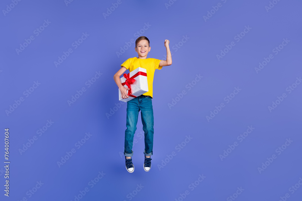 Photo of beautiful cheerful cute boy wear trendy yellow clothes celebrate birthday receiving gift isolated on violet color background Photo of beautiful cheerful cute boy wear trendy yellow clothes celebrate birthday receiving gift isolated on violet color background