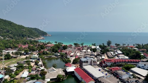 Aerial view of Haad Rin District in Koh Phangan, Thailand. Drone forward shot towards the sea.  photo