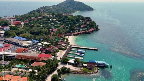 Aerial view of Haad Rin District and Haad Rin Pier (Haad Rin Queen Ferry) in Koh Phangan, Thailand. Backward drone shot.   photo