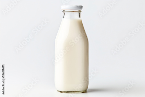 A glass bottle of fresh milk on a white tabletop. Simple and pure, perfect for breakfast.