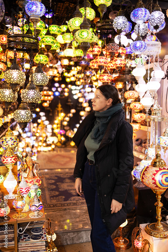 Photography Woman tourist among a Turkish lamp at the Grand Bazaar on a defocused background