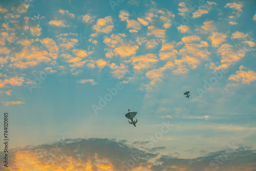 Sunset colourful kite in the sky with fluffy clouds and orange