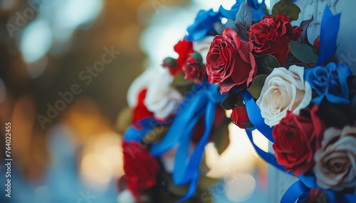 A wreath of red, white, and blue flowers is placed on a table photo
