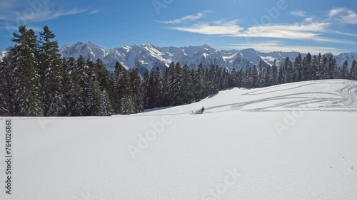 A snowmobiler is high in the mountains, riding on freshly fallen snow. snowmobile trip in the Alps at an altitude of 3000 meters. Pro snow mobile. Winter fun extreme. stock video footage. prores raw photo