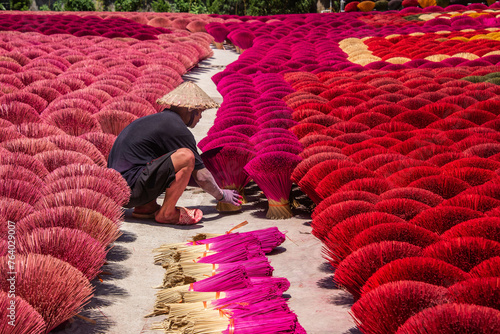 Worker drying incense in the Quang Phu Cau incense village, Hanoi, Vietnam photo