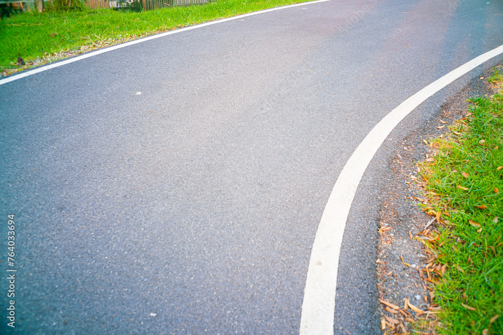 Obraz premium Empty asphalt road walking pathway in city green park