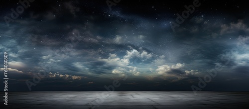 A dark sky filled with shining stars and moving clouds above an open and flat area