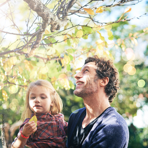 Father, daughter and smile in garden in autumn with trees, leaves and curious for ecosystem and environment. Family, man and girl child with happiness in backyard of home for bonding, nature or relax