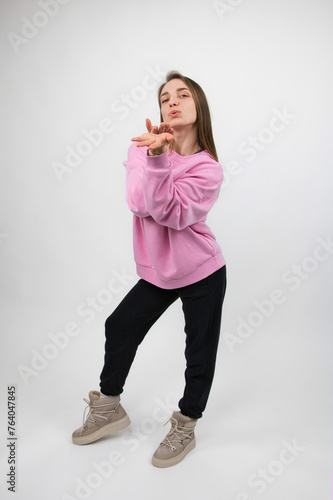 Girl athlete demonstrates the promise of a kiss by gesturing with her hands and lips, studio shot