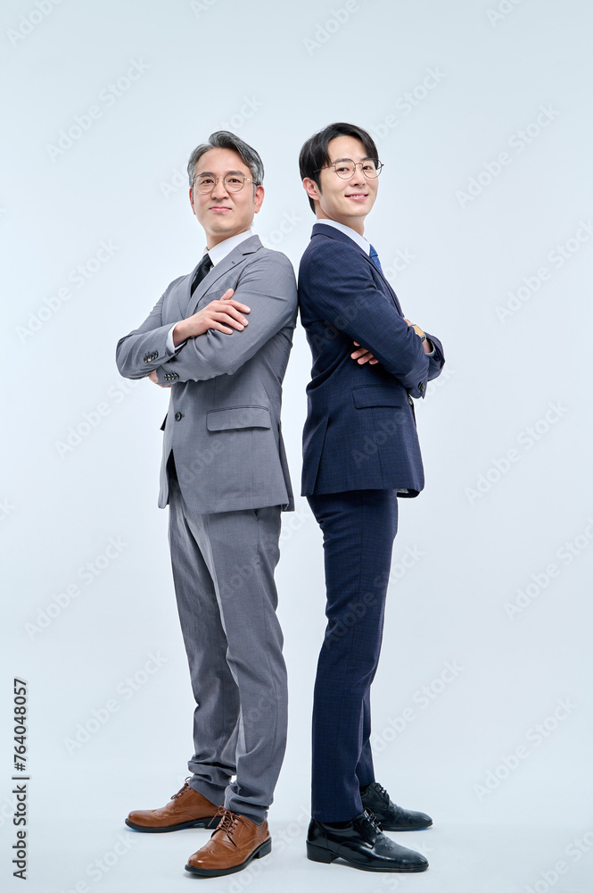 A young office worker man wearing a suit and glasses and a middle-aged man are posing with a variety of confident expressions together. A young office worker man wearing a suit and glasses and a middle-aged man are posing with a variety of confident expressions together.