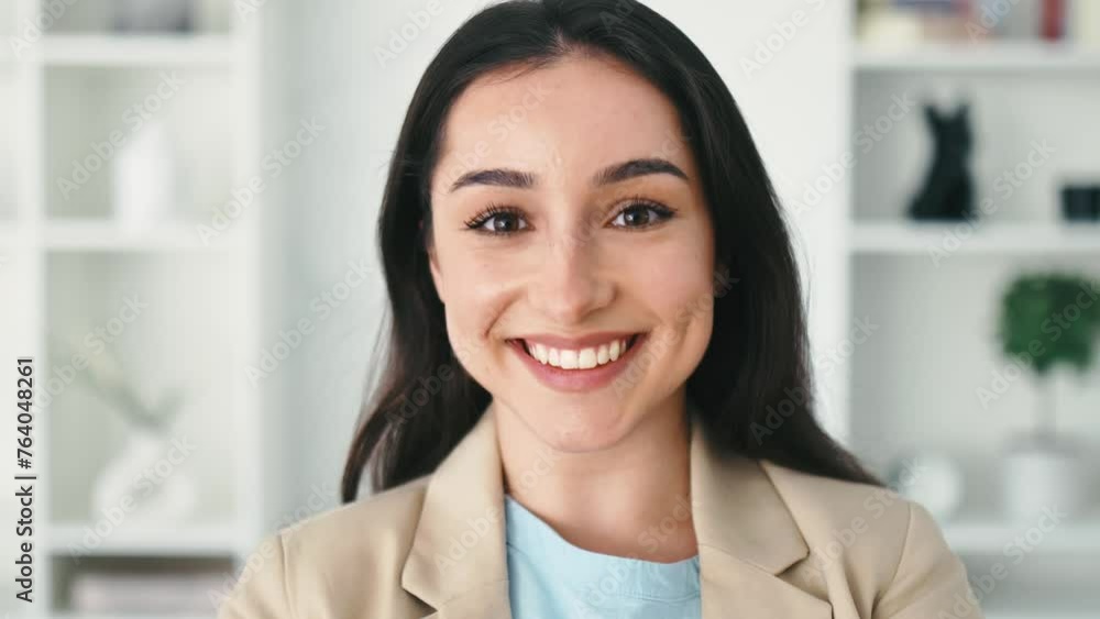 Beautiful successful brunette indian or arabian woman, ceo, real estate broker, corporate manager, dressed in elegant suit, standing in a modern office space, friendly smiling at camera Beautiful successful brunette indian or arabian woman, ceo, real estate broker, corporate manager, dressed in elegant suit, standing in a modern office space, friendly smiling at camera