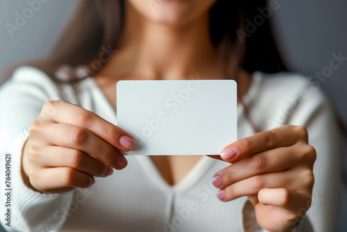 Young woman showing a blank white business card. Mockup business card template. Copy space.