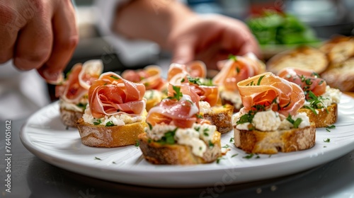 Hands artfully top toasted ciabatta with creamy cheese and prosciutto, finished with rosemary and spices