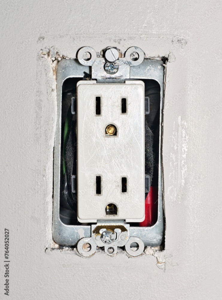 Dangerous power outlet with a broken plug prong inside, and exposed