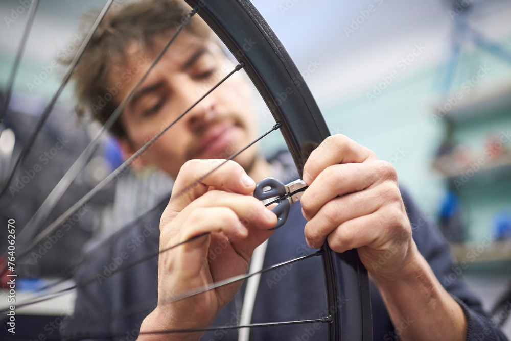 Young hispanic man using a wrench tool to adjust the tension and