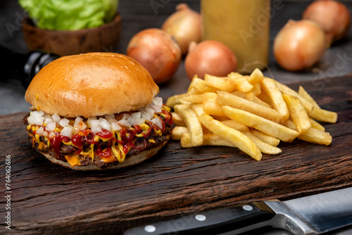 variety of homemade beef burgers with onion cucumber dressings tomato chedar cheese lettuce mayonnaise mustard ketchup barbecue with potato bun and french fries on wooden board photo