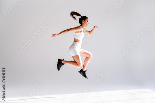 Young female athlete training in a gym using sport equipment photo