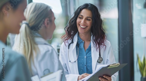 A female doctor in a white coat reviews a patient's chart with a reassuring smile photo