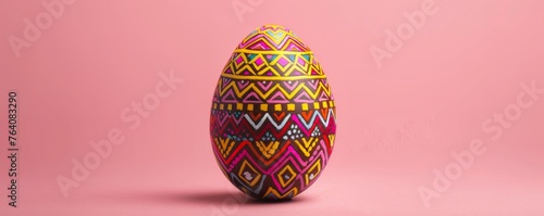 Decorative painted easter egg on pink background