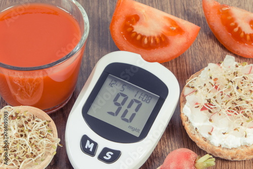 Glucose meter with sugar level, freshly breakfast and tomato juice. Healthy nutrition during diabetes