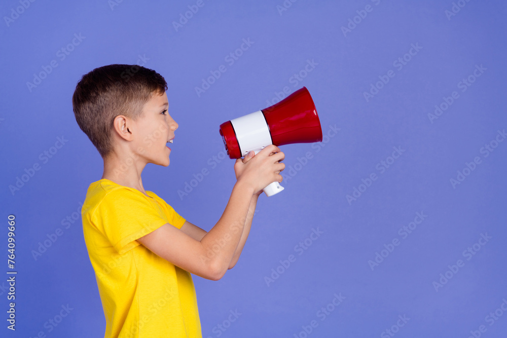 Photo of funny cheerful small boy wear stylish clothes hold toa bullhorn say news look empty space isolated on violet color background Photo of funny cheerful small boy wear stylish clothes hold toa bullhorn say news look empty space isolated on violet color background