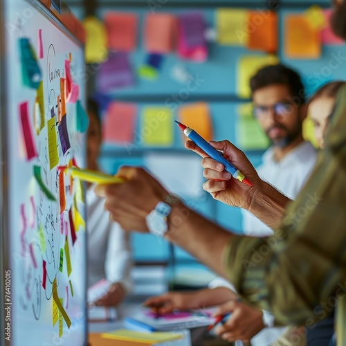 An innovative team actively participates in a brainstorming session, using sticky notes to visualize ideas during a collaborative workshop. © Riz