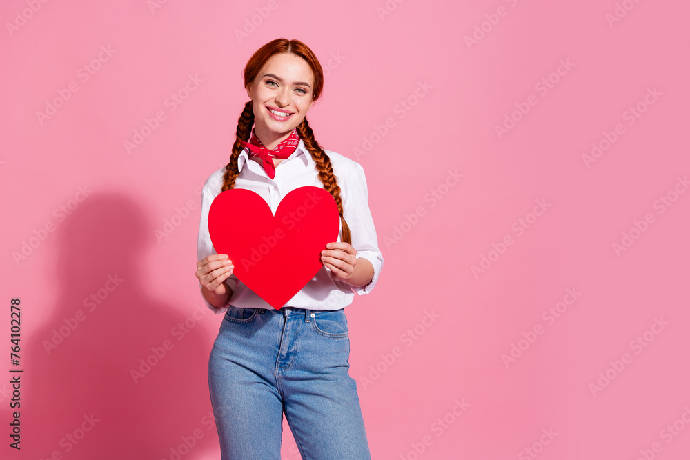 Photo of cute pretty lovely girl wear stylish clothes hands hold huge red poster placard empty space isolated on pink color background Photo of cute pretty lovely girl wear stylish clothes hands hold huge red poster placard empty space isolated on pink color background
