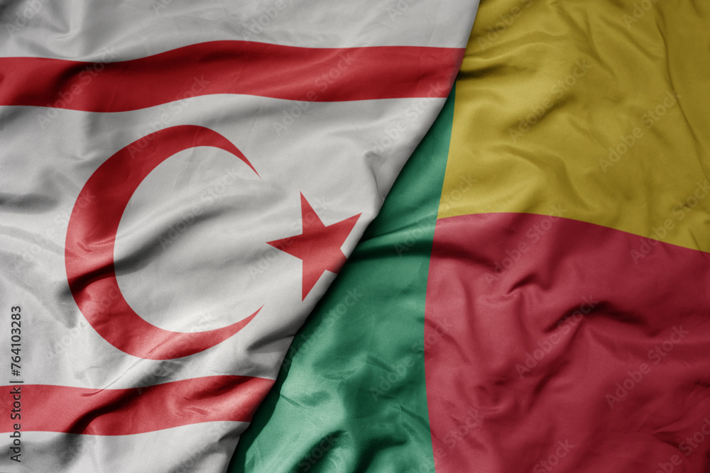 big waving national colorful flag of benin and national flag of northern cyprus.