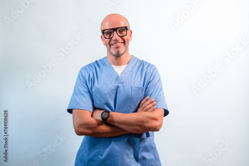 Portrait of a physiotherapist in light blue gown looking at camera in studio.