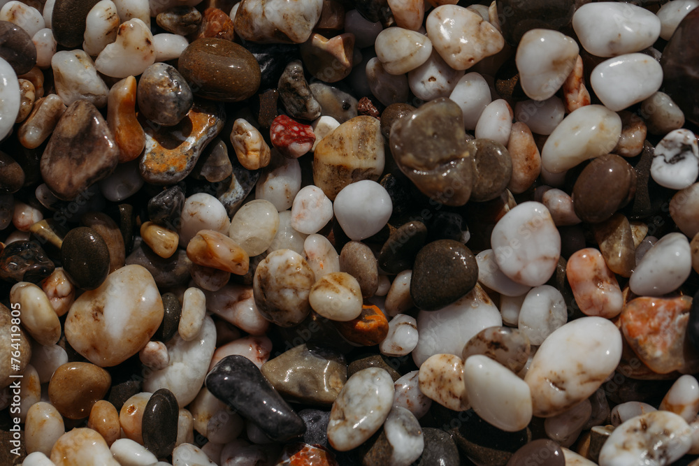 Sea stones of different colors on the shore in close-up
