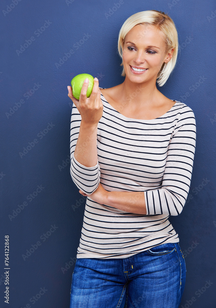 Woman, smile and apple in studio for healthy diet on blue background or fruit nutrition, snack or fibre. Female person, relax and wellness eating with mockup space or vegan detox, food or lose weight Woman, smile and apple in studio for healthy diet on blue background or fruit nutrition, snack or fibre. Female person, relax and wellness eating with mockup space or vegan detox, food or lose weight