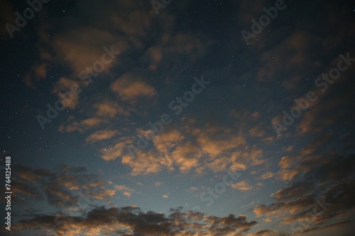 Evening orange clouds in the light of the moon stars sky