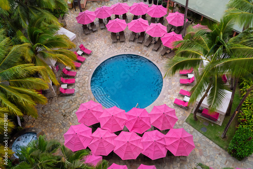 pink pool umbreallas around palm trees © jdross75