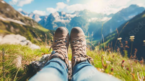 Man's foots in hiking boots. Tourist have a rest and enjoying wonderful breathtaking mountain view. Freedom, travel, trekking, hiking concept. Summer vacation in mountains photo