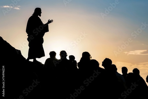 Silhouette of Jesus Christ teaching from a hilltop, crowd of people listening below.
