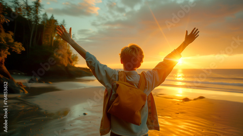 A person raising arms high in celebration facing the sunset on a serene beach
