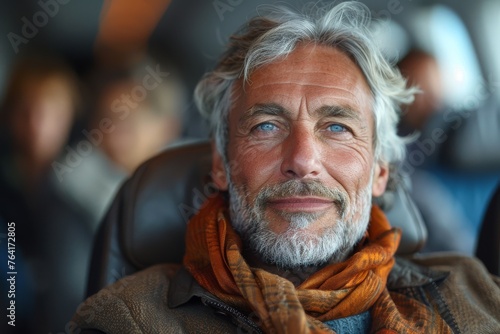 A charming mature man smiles warmly while seated in an airplane cabin