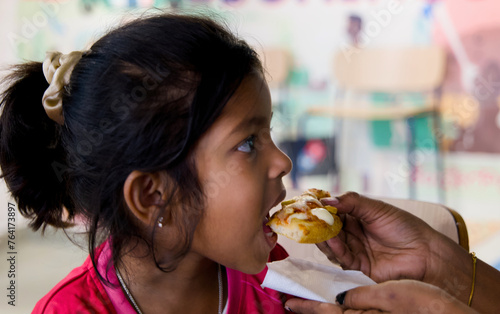 Young girl eating pizza in the restaurant Selective focus and mom feeding pizza
