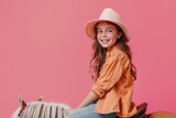 Girl hobbyhorsing on solid color background