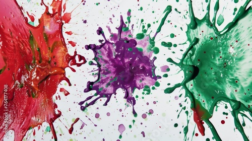 Three vividly colored paints have been splattered across a pristine white surface, creating a dynamic and vibrant artistic display. Each paint splatter stands out uniquely, adding interest and contras photo