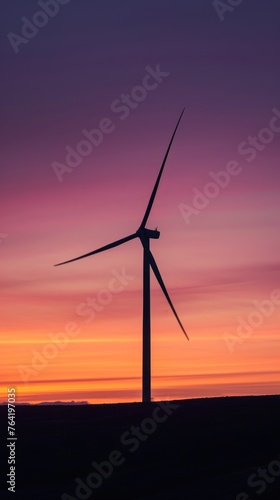 a single wind turbine silhouetted against a vibrant sunset, ideal for environmental campaigns or educational material on renewable energy.