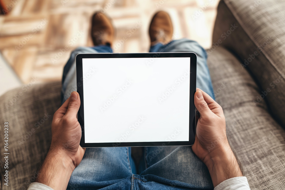 Male hands holding tablet with blank white empty screen, concept of technology use in everyday life, mockup tablet