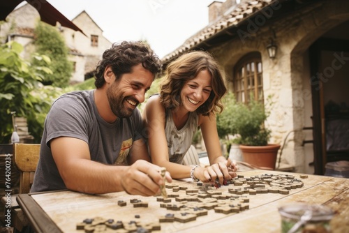 A couple enjoying a relaxing game of Carcassonne, placing tiles to build cities and roads in medieval France photo