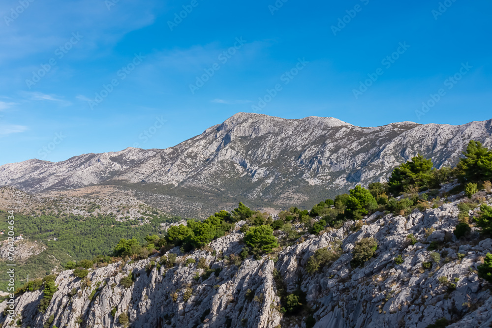Idyllic hiking trail to medieval fortress Starigrad in Omis, Split-Dalmatia, Croatia, Europe. Panoramic view of mountain peak Sveti Jure in Dinara mountains, Dinaric Alps in the Balkans. Wanderlust