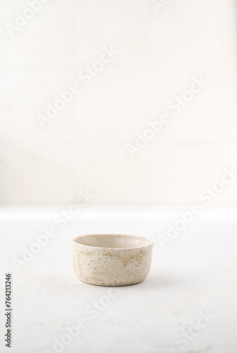 Fototapeta Naklejka Na Ścianę i Meble -  a small ceramic sauce pan on a white background with a place for text. Japanese style. Wabi-sabi.