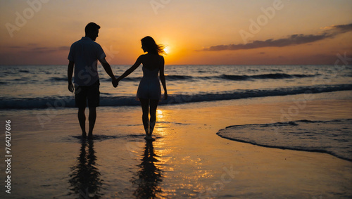 A couple in love at sunset walks along the seashore holding hands. Romance at sunset